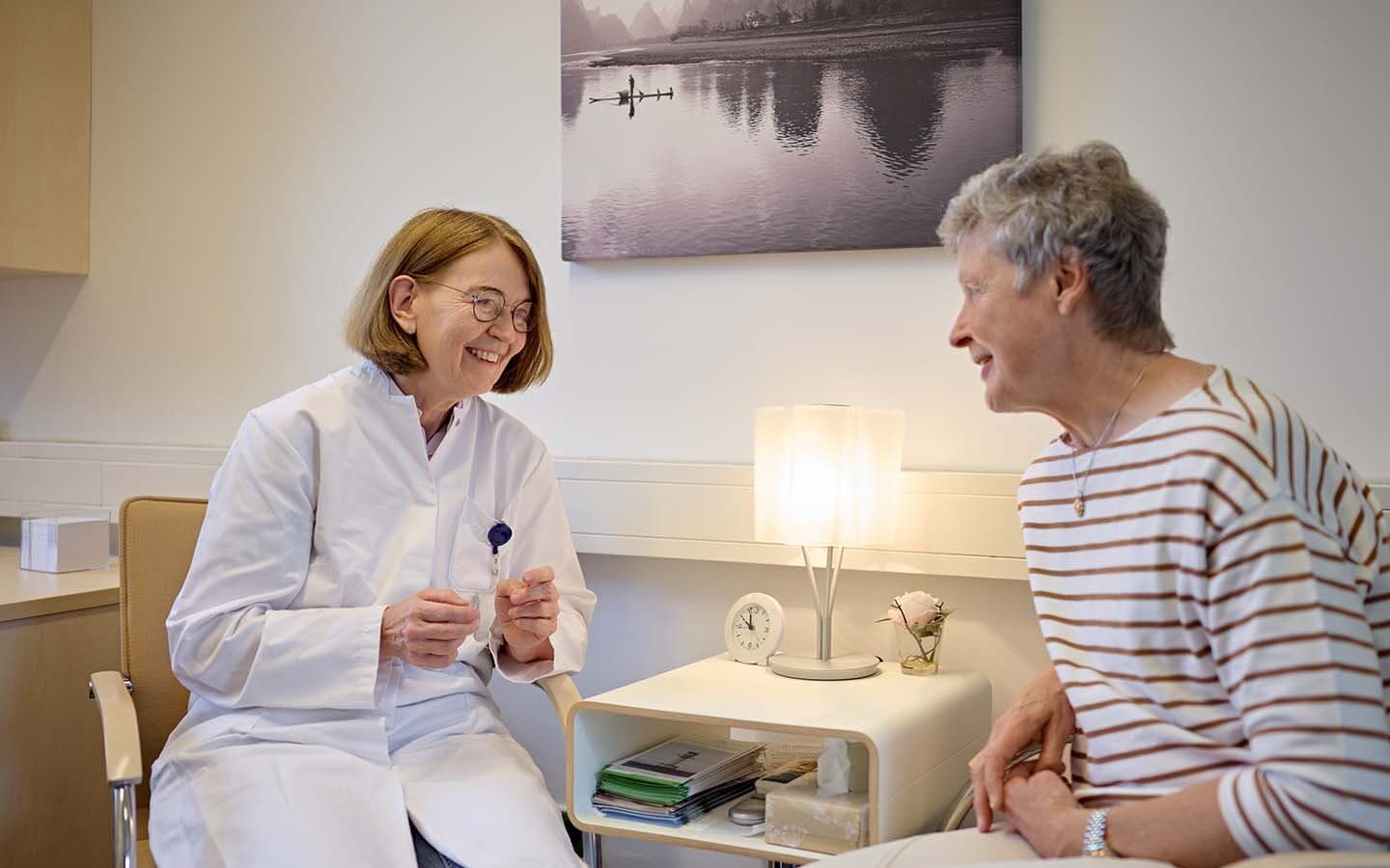 Eine Ärztin der zweiten Medizinischen Klinik im Gespräch mit einer Patientin in einem Behandlungsraum.